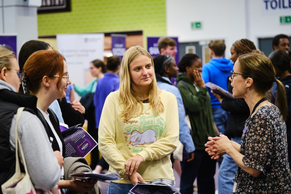 Students talking to a staff member at an exhibition